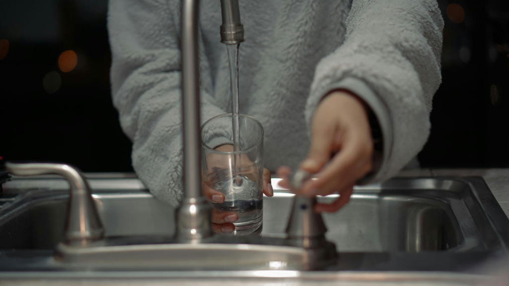 image pouring a glass of water from kitchen sink