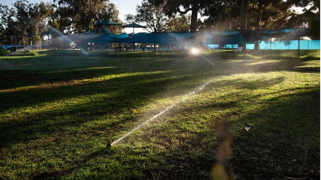 Sprinklers water a lawn in Los Angeles on June 5, 2022. Under new proposed rules, water agencies in California's urban areas will have to meet mandatory water conservation cuts. (Pablo Unzueta/CalMatters)