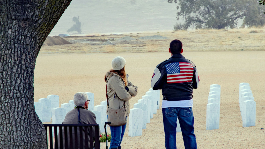 Three people observing. Taken during the laying of the wreaths at the Bakersfield National Cemetery